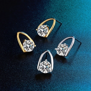 Detail view of gold and silver S925 sterling silver stud earrings with round moissanite