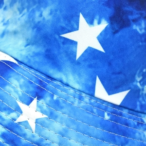 Macro detail of star pattern on tie-dye fabric with precision stitching on a bucket hat