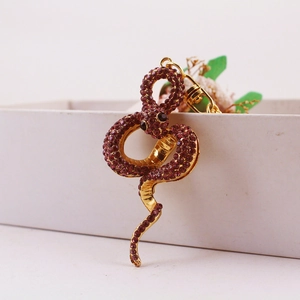 Goldener Schlangen-Schlüsselanhänger mit funkelnden rosa Kristallen und Metallring