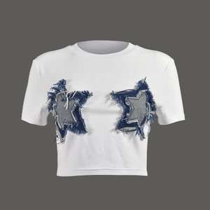Detail of white cropped T-shirt featuring two blue denim star patches with fringe trim