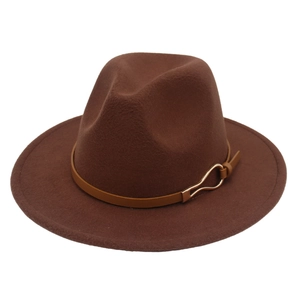 Gros plan sur un chapeau fedora en feutre marron avec bande en cuir et boucle dorée.