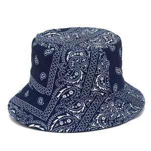 Detail of dark blue reversible bucket hat featuring white paisley print on cotton fabric