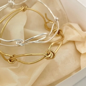 Detailed view of 925 sterling silver knotted bracelets in gold and silver finish