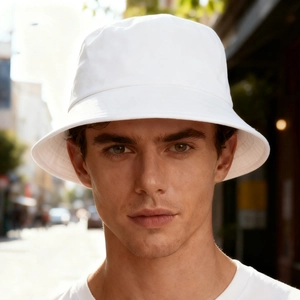 Outdoor street style photo of a man wearing a classic white cotton bucket hat for sun protection