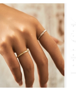 Close-up of minimalist gold and silver rings with zircons on model fingers