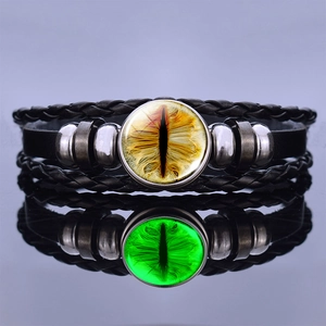 Luminous dragon eye leather bracelet showing glowing green and yellow effects in a mirror