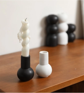 Detail of minimalist black and white ceramic candle holders with spiral wax candles