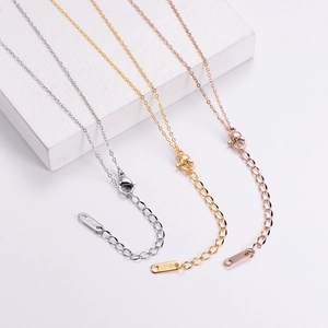 Detailed close-up of 18KGP gold plated necklace chain adjustment links and tag