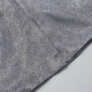 Detailed macro view of silver sequin fabric texture with metallic luster on the 3-piece set