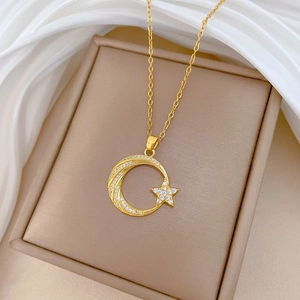 Détail du collier en acier titane doré avec pendentif lune et étoile étincelant