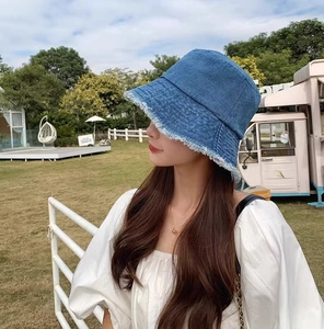 Détail du chapeau bob en denim bleu délavé avec bords effilochés stylés et visière solaire