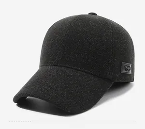 Detail view of the side leather patch and metal shield emblem on dark grey wool baseball cap
