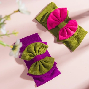 Detail of baby headbands featuring large double-layered bows and textured knit fabric