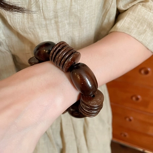 Detail of vintage coconut shell and wood beads bracelet on wrist with natural texture