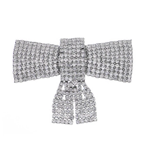 Macro detail of silver bow brooch with sparkling rhinestones and elegant fringe tassels