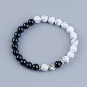Yin Yang Tai Chi bracelet with black beads and white marble stones on grey background