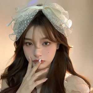 French style white polka dot mesh bow hair clip elegantly worn by a model
