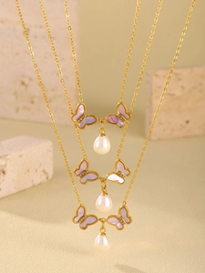 Détails des pendentifs papillons et perles en forme de goutte sur colliers dorés