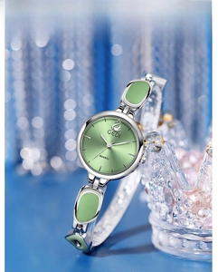 Detail view of GEDI quartz watch with green dial and silver bracelet next to a crystal crown