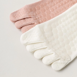 Detail of pink and white five-finger yoga socks with anti-slip silicone dots and knit texture