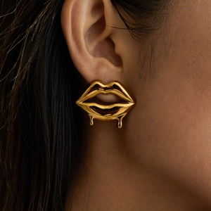 Chic gold liquid cherry earrings with dripping metallic texture on female model's ear