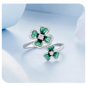 Macro detail of silver adjustable ring with green enamel clovers and white zircons