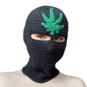 Handmade black crochet balaclava mask featuring a green leaf patch for winter warmth