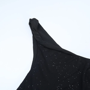 Detail of black shimmer fabric dress featuring elegant knot design and sparkling sequins