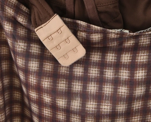 Detalle de tela de cuadros marrón y botones beige en un top corto sexy vintage