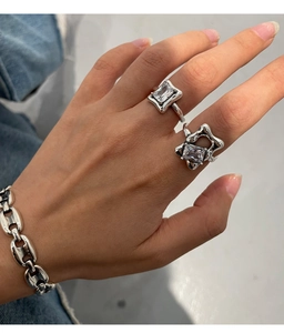 Detailed shot of two 925 silver rings with square crystals on a female model's hand