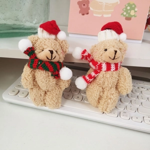 Detailed view of two plush teddy bears with red Christmas hats on a white keyboard