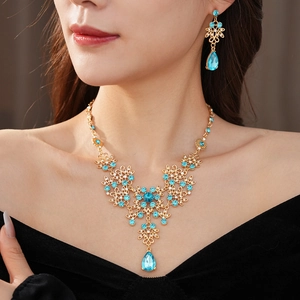 Detailed view of vintage gold necklace and earring set with blue drop-shaped gemstones