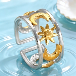 Detail van holle dubbele ring met zon- en maanmotieven en gouden accenten