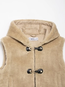 Detail of camel faux fur hooded vest with black leather trim and golden metal buckles