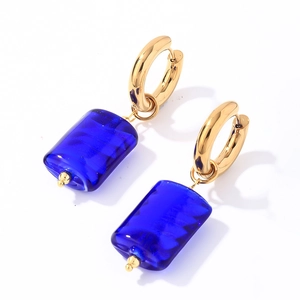 Detailed close-up of gold stainless steel hoop earrings with blue natural stone pendants