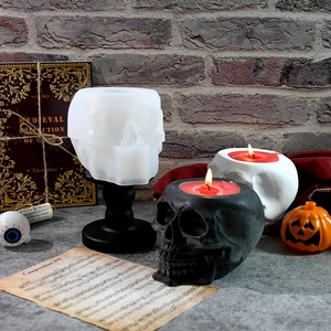Macro detail of skull-shaped silicone mold and burning candles for Halloween DIY crafts
