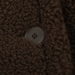 Macro view of dark brown sherpa fleece texture and matching four-hole matte button detail