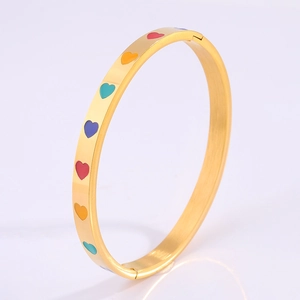 Detail shot of the gold buckle structure and colorful enamel heart patterns on the bangle