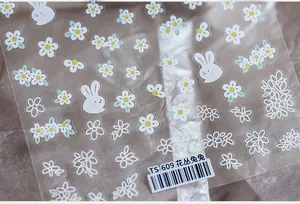 Close-up of 5D nail art stickers TS-609 featuring rabbits and white floral patterns