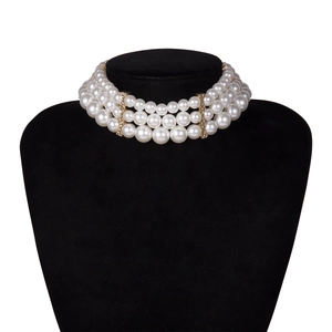 Close-up of triple-layered pearl choker necklace with gold metal spacers on display