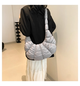 Detailed view of grey pleated crossbody bag with large capacity shown on model