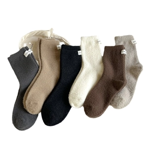 Pack of 6 thick winter fuzzy crew socks in assorted neutral tones with brand labels