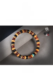 Close-up of colorful wooden cylinder beads on a traditional Buddhist stretch bracelet