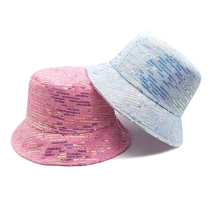 Detail of sequined bucket hats in pink and blue showing the shiny textured fabric surface
