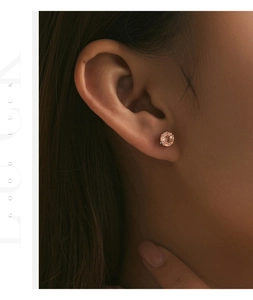 Close-up of a s925 silver champagne pink diamond earring worn on a female ear lobe