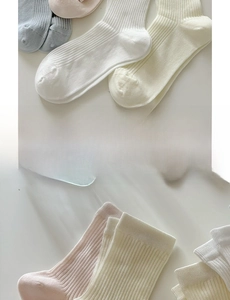 Gros plan de chaussettes en coton pastel avec tricot à côtes verticales et bords festonnés