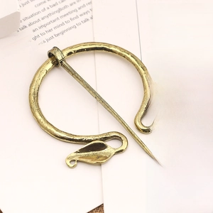 Detailed macro view of vintage bronze viking cloak pin with leaf-shaped metal ornaments