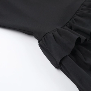 Detaillierte Makroansicht des schwarzen Volants an einem trägerlosen Mini-Stufenkleid