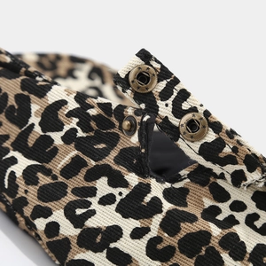 Macro shot of leopard print beret texture and vintage metal star embossed button detail