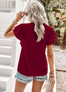 Outdoor back view of short sleeve V-neck blouse with ruffle cuff details in deep red